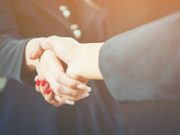 Zwei Menschen schütteln Hände. Startups. Agillic